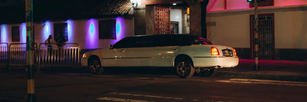 White stretch limousine on a city street at night